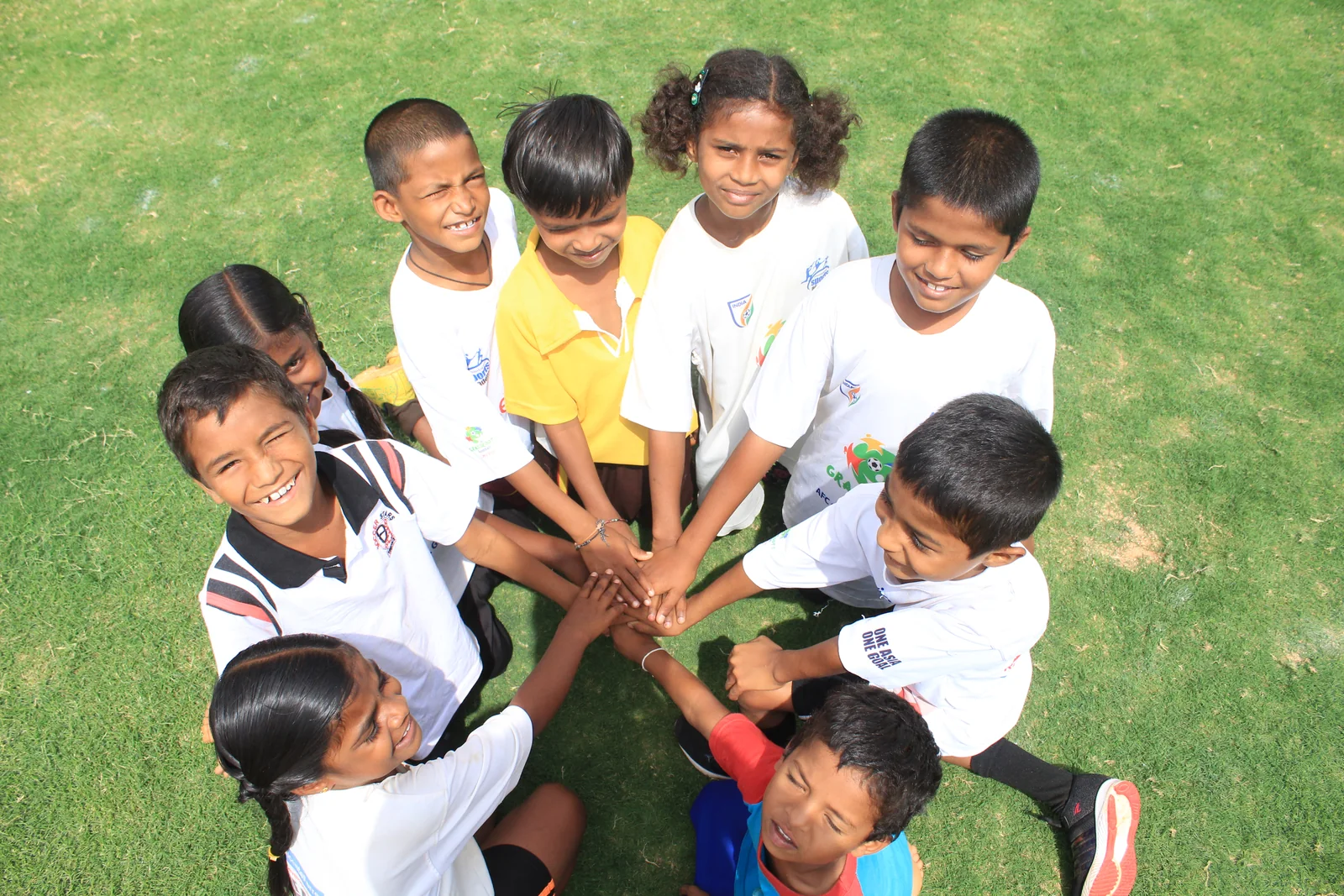 Young ASA athletes smiling together in a team huddle on the playing field